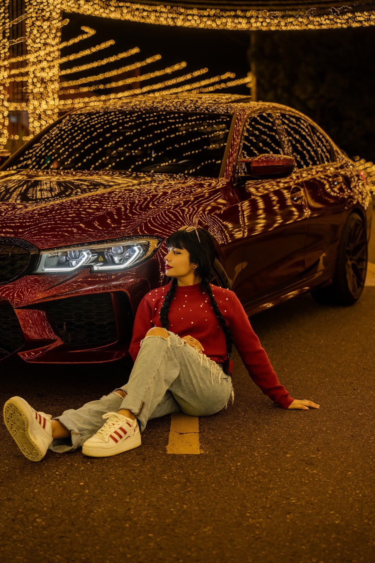 BMW M340i xDrive — Luces nocturnas reflejadas sobre la carrocería roja.